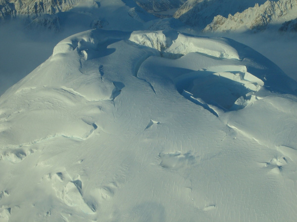 Oblique photo of the melt pit on Spurr's summit, looking southwest. "Peter's puka" is steaming in the foreground.