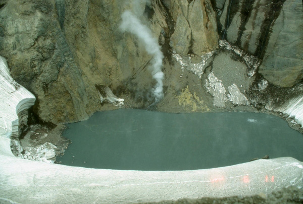 In early June, 1992, this lake inside Crater Peak vent 
at Mount Spurr volcano had a temperature of 49.7C (121F) 
and a pH of 2.5. Note a circular upwelling zone about 5 m 
(16 ft) across at the middle right, and the vigorously 
steaming talus pile on the far shore. Photograph by Game 
McGimsey, U.S. Geological Survey, June 11, 1992.