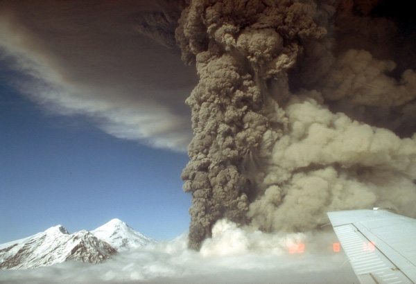 Aerial view, looking north, of the eruption column from 
the Crater Peak vent, Mount Spurr volcano. A light-tan 
cloud ascending from pyroclastic flows is visible at right. 
The 3,374-m (11,070 ft)-high summit lava dome complex of 
Mount Spurr is visible at left. Photograph by R. McGimsey, 
U.S. Geological Survey, August 18, 1992.