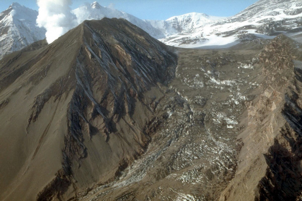 The final 1992 eruption of the Crater Peak vent, Mount 
Spurr volcano, showered hot debris onto the Kidazgeni 
Glacier immediately east of Crater Peak. In this view, 
steam billows from Crater Peak. Dark pyroclastic material 
blankets the flanks of Crater Peak and the adjacent glacial 
ice. Photograph by C. Gardner, U.S. Geological Survey, 
September 23, 1992.