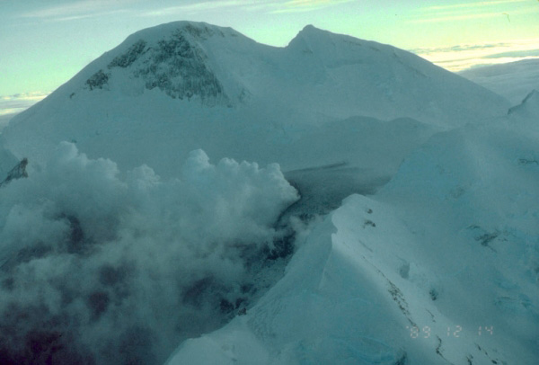 Aerial view, looking southeast, at the summit of 
Redoubt Volcano. Prior to the onset of the 1989 to 1990 
eruptions of Redoubt Volcano, melting of the summit crater 
ice cap caused by heat from rising magma produced a 
vigorous steam plume. Photograph by H. Twitchell, National 
Park Service, December 14, 1989.