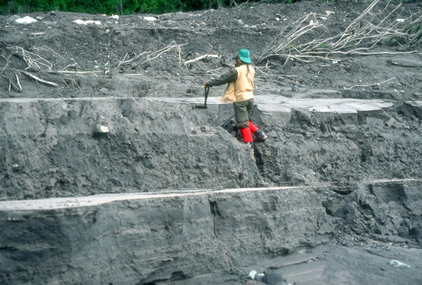 Where exposed by subsequent stream downcutting, lahar 
deposits from the 1989 to 1990 eruptions of Redoubt Volcano 
consisted of layers of sand- to boulder-sized debris.  Cynthia Gardner measuring deposit thickness. 
Photograph by G. McGimsey, U.S. Geological Survey, June 15, 
1990.