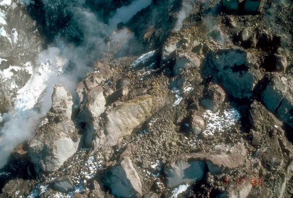 Aerial view of the highly irregular, steep north face 
of the final lava dome of the 1989 to 1990 series of 
eruptions of Redoubt Volcano. The surface consists of 
blocks of slightly vesicular to dense andesite lava up to 
30 m (100 feet) across. Yellow sulfur deposits are visible 
on a block of lava at center of view. Photograph by C. 
Neal, U.S. Geological Survey, July 17, 1990.
