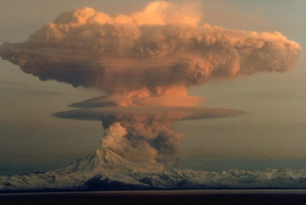 Ascending eruption cloud from Redoubt Volcano as viewed 
to the west from the Kenai Peninsula. The mushroom-shaped 
plume rose from avalanches of hot debris (pyroclastic 
flows) that cascaded down the north flank of the volcano. A 
smaller, white steam plume rises from the summit crater. 
Photograph by R. Clucas, April 21, 1990.