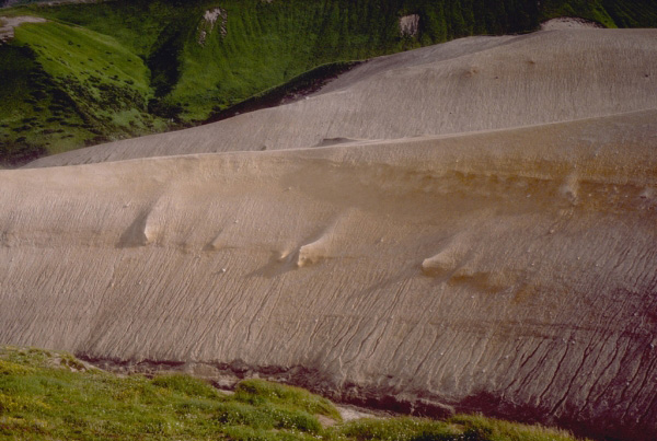 Ash flows from an eruption that formed a small caldera between 3,600 and 4,700 years ago. The caldera is on the eastern edge of the Black Peak volcanic center on the Alaska Peninsula. Photograph by T. Miller, U.S. Geological Survey, October, 1985.
