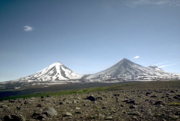 Pavlof (2,519-m [8,264 ft]-high, right) and Pavlof Sister (2,143-m [7,031 ft]-high, left) are a pair of symmetrical stratovolcanoes on the Alaska Peninsula. Pavlof Volcano is one of the most active of Alaska's volcanoes with nearly 40 historical eruptions. View is from the northwest. Photograph by T. Miller, U.S. Geological Survey, July, 1975.