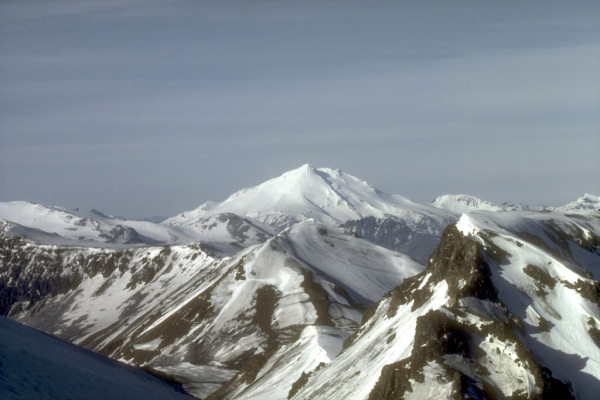 Mount Dutton, a 1,506-m (4,941 ft)-high stratovolcano, lies 14 km (9 mi) north of the community of King Cove on the Alaska Peninsula. The summit of Mount Dutton is composed of a cluster of lava domes. Mount Dutton has had no historical eruptions. However, seismic swarms beneath the volcano were recorded in 1984 to 1985 and again in 1989.  View is to the southwest. Photograph by M.E. Yount, U.S. Geological Survey, July, 1986.