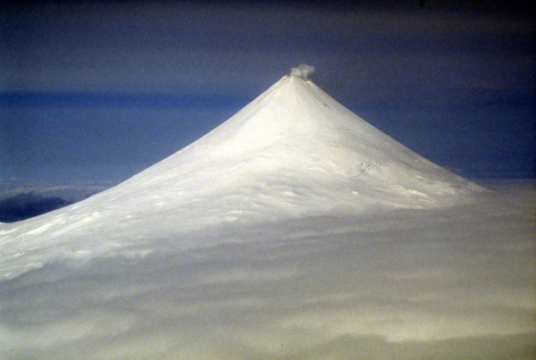 Often compared to Mount Fuji, Japan, the symmetrical Shishaldin volcano located on central Unimak Island in the Aleutian Islands rises 2,857 m (9,373 ft) above sea level. The volcano has had several historical eruptions. A summit crater emits a nearly continuous plume of steam. Photograph by C. Nye, Alaska Division of Geological and Geophysical Surveys, May 10, 1994.