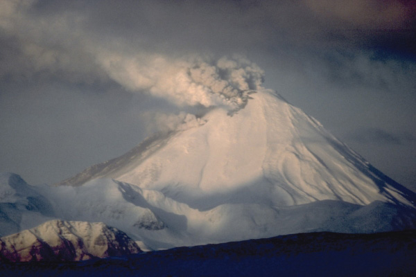 View, looking west, of 1,312-m (4,304 ft)-high Kanaga Volcano in eruption. Kanaga is located about 25 km (16 mi) west of the U.S. Navy installation and port on Adak Island in the Aleutian Islands. The volcano erupted intermittently through much of 1994, dusting the community of Adak at least once with fine ash. Photograph by E. Klett, U.S. Fish and Wildlife Service, January 27, 1994.