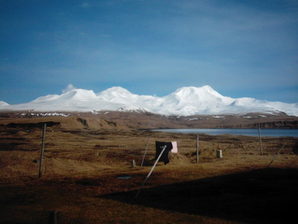 Steam rising above Korovin Volcano (on far left skyline) on northern Atka Island about noon on February 23, 2005, a prelude to a minor eruption later that day. View is from Atka Village. Photograph courtesy of Louis and Kathleen Nevzoroff.