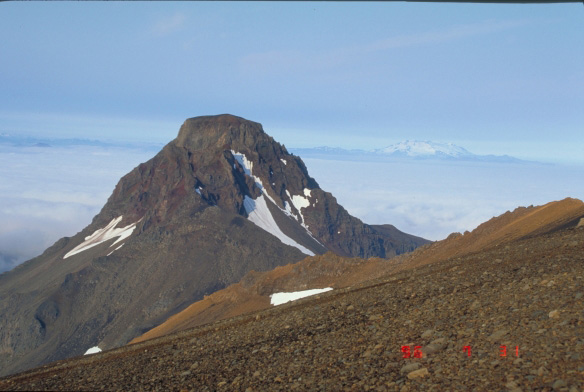 Flat Top Peak, Akutan Volcano.  Snow-capped Makushin Volcano is visible in the distance.