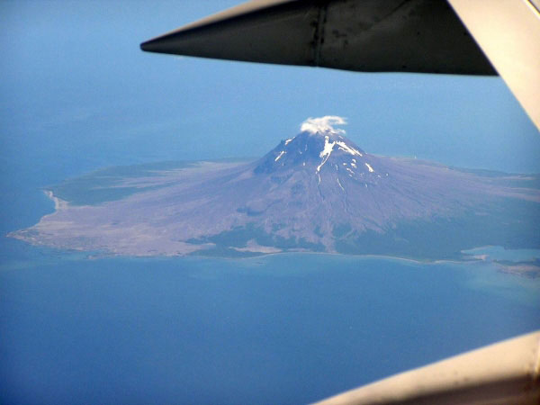A view from a plane of Mt. St. Augustine located in the Cook Inlet of Alaska. The view is to the southeast from the plane. In the photo the large debris flow fan deposit on the northern flank of the volcano is visible along with some lava flows on the upper flanks of the edifice.
