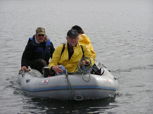 Deck hand/skiff driver, Scott Kerr (left-back), navigates the skiff out to the Augusta D from the beach at Nikolski on Umnak Island, AK. Others in the skiff are: Jon Dehn (right-obscured; UAF/GI/AVO) and Richard Moore (center-front; USGS). The group was heading out to Mt. Cleveland to begin the 2003 fieldwork.