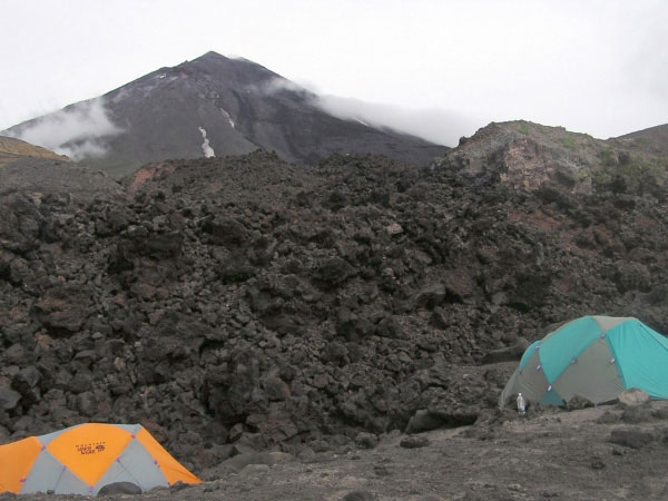 The western flank of Mt. Cleveland volcano as seen from the 2003 campsite. The camp was located at the highest portion on the volcaniclastic debris flow fan deposit at the point where the northern fork of the 2001 lava flow forks again as it encountered the fan deposit. On the upper flank of the volcano the main levee(s) of the 2001 lava flow is (are) evident from the channel appearance.