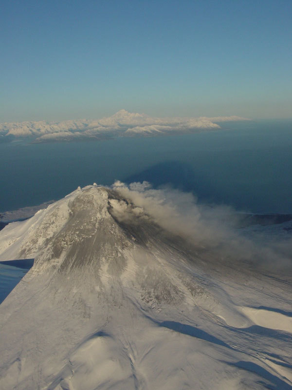 Steam issuing from multiple fumaroles on the summit, and upper southeast flank; steam and gas plume trailing 75 km downwind to southeast