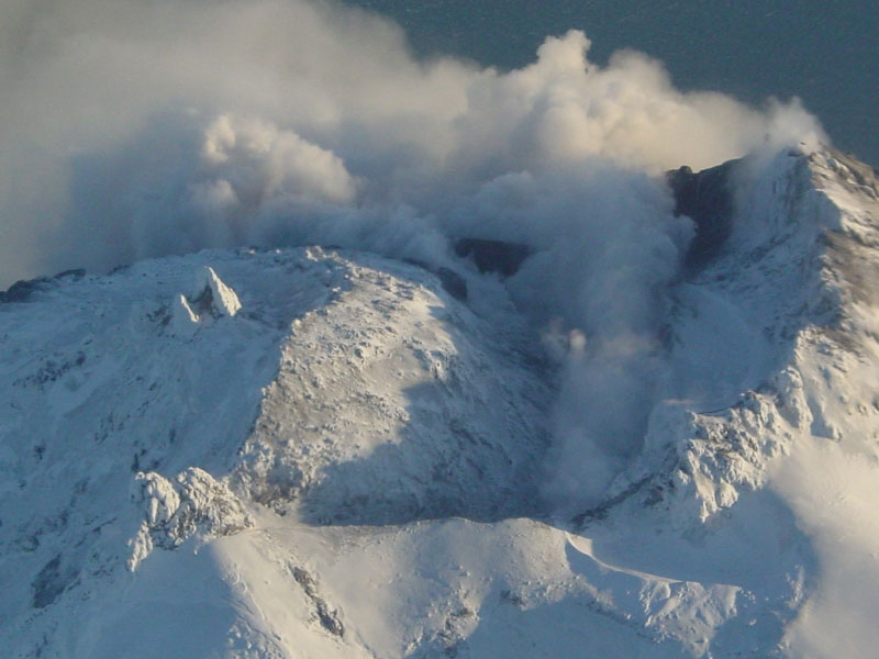 Steam issuing from multiple fumaroles on the summit, and upper southeast flank; steam and gas plume trailing 75 km downwind to southeast