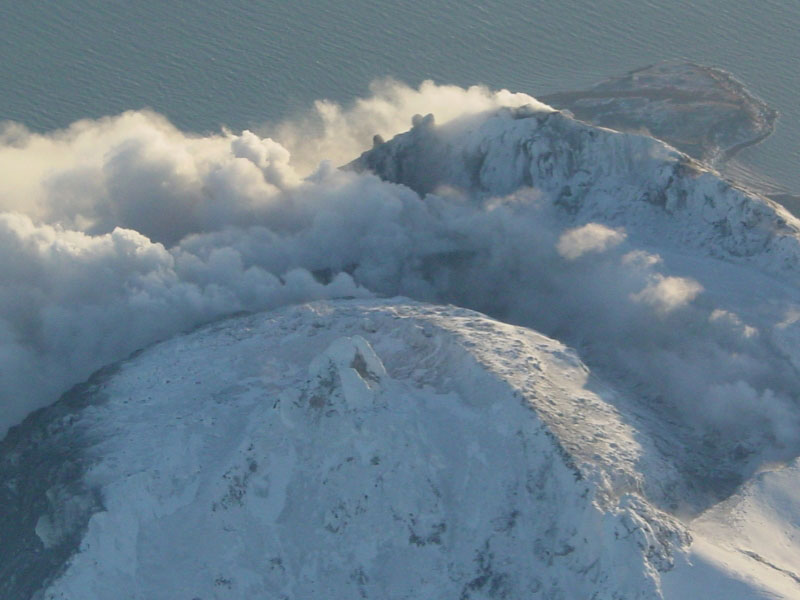 Steam issuing from multiple fumaroles on the summit, and upper southeast flank; steam and gas plume trailing 75 km downwind to southeast