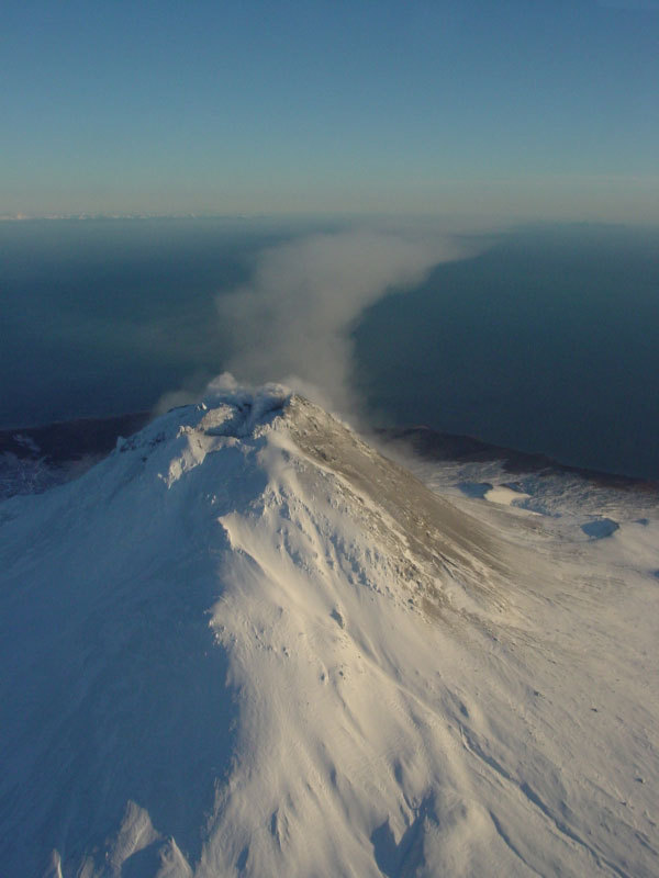 Steam issuing from multiple fumaroles on the summit, and upper southeast flank; steam and gas plume trailing 75 km downwind to southeast