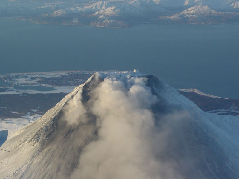 Steam issuing from multiple fumaroles on the summit, and upper southeast flank; steam and gas plume trailing 75 km downwind to southeast