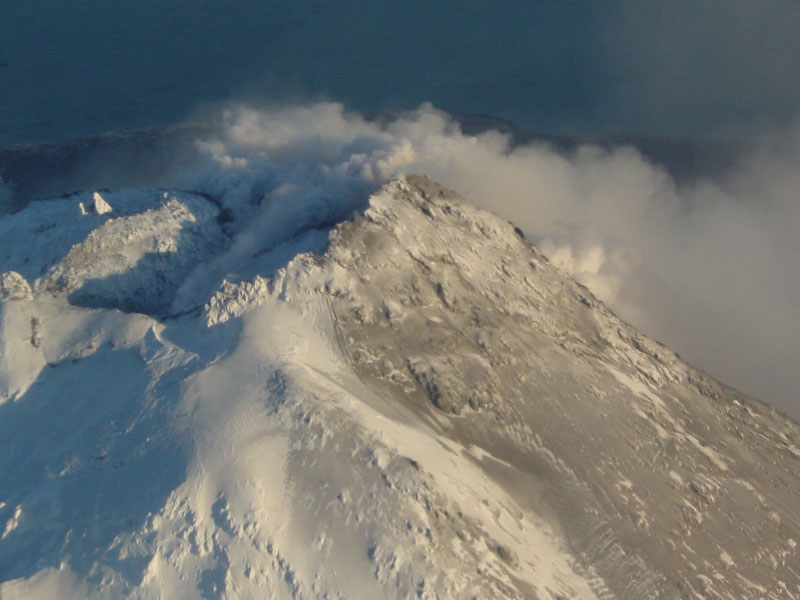 Steam issuing from multiple fumaroles on the summit, and upper southeast flank; steam and gas plume trailing 75 km downwind to southeast