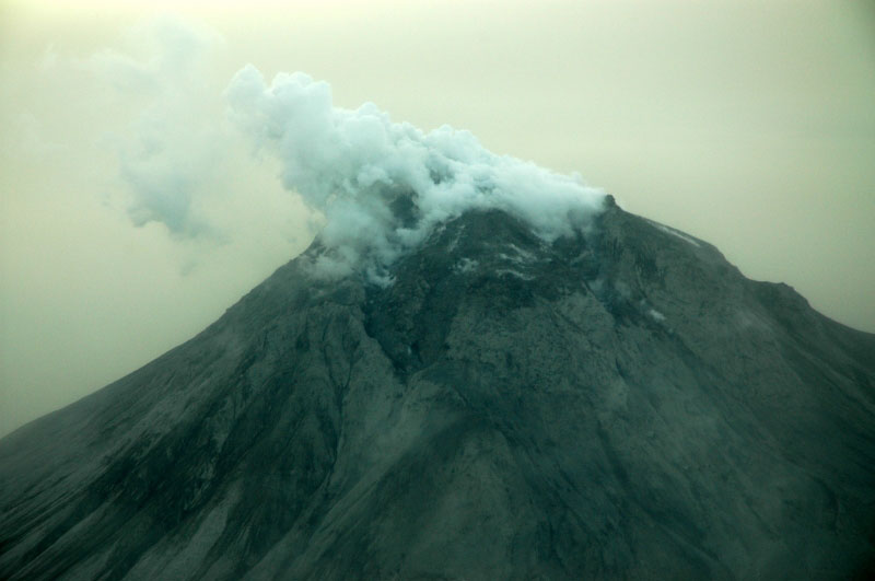 Augustine Volcano. Image from observation flight on the afternoon of 1/17/06. The explosive event earlier in the morning produced a brown haze due to suspended ash in the air. Airborne ash prevented scientists from approaching the volcano closely.
