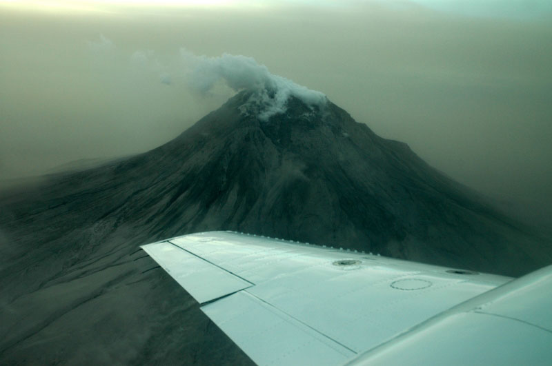 Augustine Volcano. Image from observation flight on the afternoon of 1/17/06. The explosive event earlier in the morning produced a brown haze due to suspended ash in the air. Airborne ash prevented scientists from approaching the volcano closely.