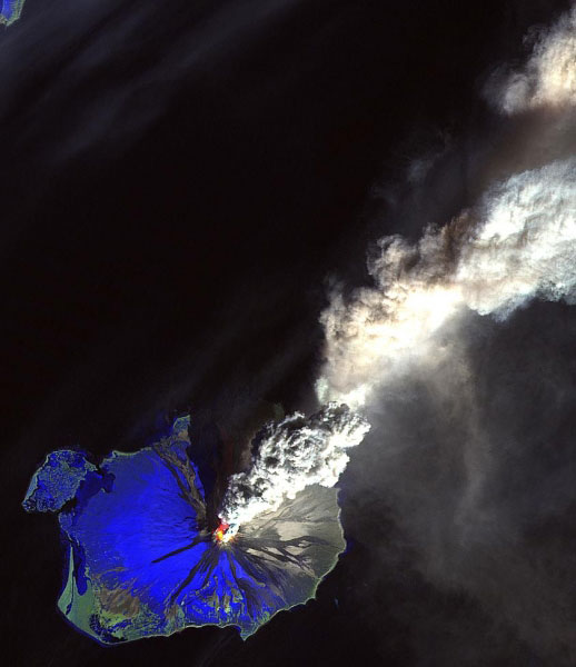 Non-annotated false color composite satellite image of the main eruption of Mount Saint Augustine volcano in 1986. The volcano is located in the southwestern part of the Cook Inlet of Alaska. The volcano makes up its own island within the inlet. The eruption lasted from March to August 1986, though some minor activity was observed as late as 1989. Composite produced with a Red-Green-Blue channel combination of Band 7 - Band 5 - Band 4 respectively. This combination produces an image that brings out the hotter regions (hottest appears as yellow color). There is a large pyroclastic flow on the northern flank of the volcano that has a slight reddish appearance. The ash rich plume can be seen extending to the northeast with some of the lower ash material being blown to the east through southeast over the Cook Inlet. Some ash deposition of the larger material can be seen as a grayish color on the northeastern side of the island. Mud flows can also be seen as darker lobes extending down all flanks of the volcano. Snow appears as a blue color. The image was run through a linear 2 percent enhancement.