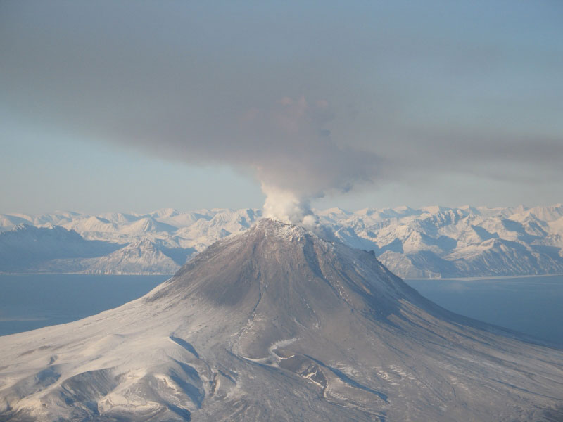 Augustine Volcano on January 24, 2006.  Steam and gas plume is drifting to the S SE.  The pinkish/brown haze in the foreground is smog from volcanic gases in the plume.  This photo was taken during a gas flight where a fixed-wing plane flies through the diffuse plume measuring gases.