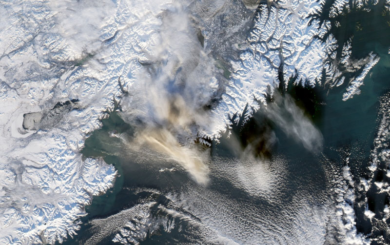 The Moderate Resolution Imaging Spectroradiometer (MODIS) flying onboard the Aqua satellite captured this image on January 13, 2006. In this image, a discernible steam and ash plume streams from the small volcanic island and heads eastward over the ocean. The brown and white cloud of material in the middle of the image is likely composed of volcanic material from Augustine. To the east, a distinct cloud formation appears. Land surface areas are covered with snow, although the volcanic island looks darker, as if its own snow cover has melted or been buried by volcanic debris.