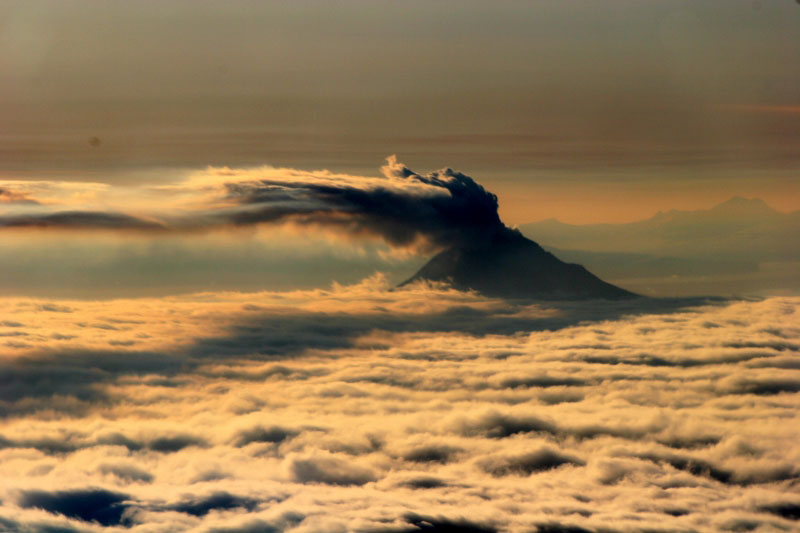 Augustine Volcano - 1/18/06. A vigorous steam plume travels many miles to the east at an approximate altitude of 8500 ft. The cloud deck is at approximately 4000 ft.
