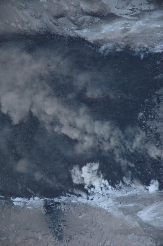 Close-up of the active front of the northeast lava flow.  White steam is produced along the margins where hot blocks are in contact with snow;  the incandescent blocks spalling off the flow front generate the brown ash clouds.