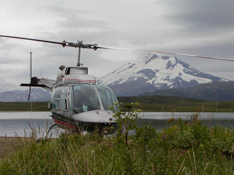 Helicopter pilot Sam Egli of Egli Air Haul departs Mother Goose Lake with Chiginagak Volcano in the background.