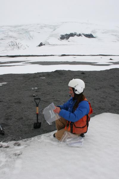 AVO staff getting ready to sample the thin debris flow deposit on the surface of the ice field north of Fourpeaked volcano.  The debris flow originated from a glacial outbreak flood caused by melting of summit glacial ice by volcanic processes on September 17, 2006. View is looking to the east, southeast.