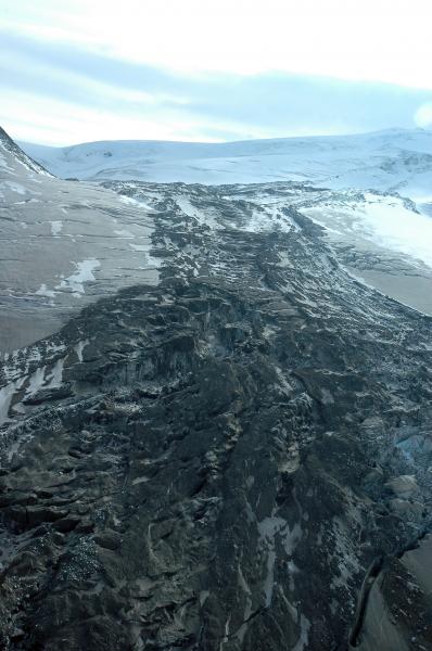 Photograph of flowage deposit on the NW flank of Fourpeaked volcano. The debris and ice flow originated from a glacial outbreak flood caused by melting of summit glacial ice by volcanic processes on September 17, 2006.  View is from the SW looking up slope.