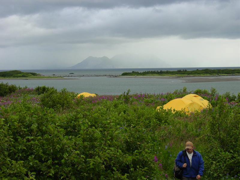 Augustine Field work, August, 2006. Iliamna voclano just obscured by clouds from Augustine camp. Dan Jones (AVO-UAF) in foreground.