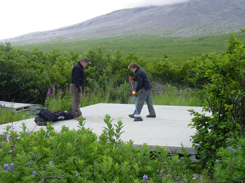 Augustine Field work, August, 2006. Tina Neal and Game McGimsey (AVO-USGS) sweeping off tent platform prior to erecting the kitchen tent.
