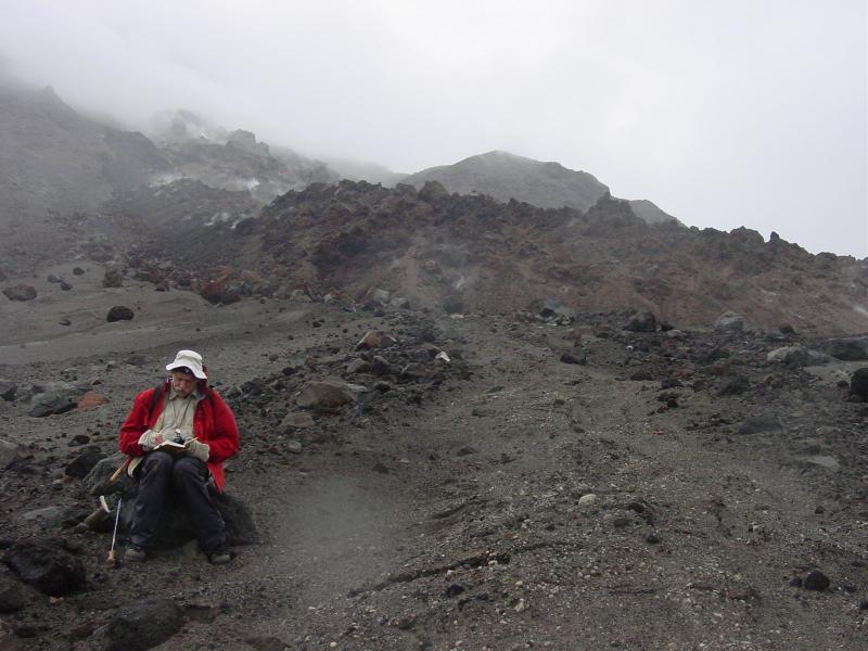 Augustine Field work, August, 2006. Dr. Jim Vallance (CVO) taking notes on levee of block-and-ash flow. Northeast lava flow in background.