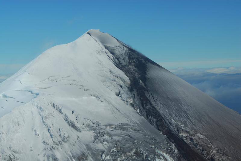Pavlof summit and southeast flank as viewed from the air looking north. Triangular shaped 2007 crater, and spatter-fed lava flow evident in photograph. 