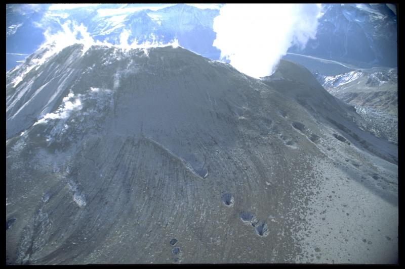 Northeast flank of Crater Peak following the August 1992 eruption.  Striated patterns probably represent flow paths for pyroclastic flows that occurred during the Aug. 18 eruption and possibly flows from earlier eruptions.  Large circular areas may be collapse pits where newly emplaced tephra fall/flow has covered and then fallen into crevasses or gullies buried beneath snowfields.