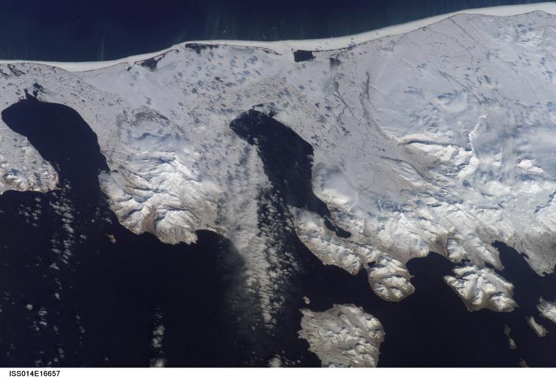 The western tip of the Alaska Peninsula, as viewed from space.  Dutton, partially obscured by clouds, is on the eastern part of the image, while Frosty is just left of center.   This photograph is mission ISS014, Roll E, Frame 16657 from Image Science and Analysis Laboratory, NASA-Johnson Space Center. "The Gateway to Astronaut Photography of Earth." and is available at http://eol.jsc.nasa.gov/scripts/sseop/photo.pl?mission=ISS014&roll=E&frame=16657