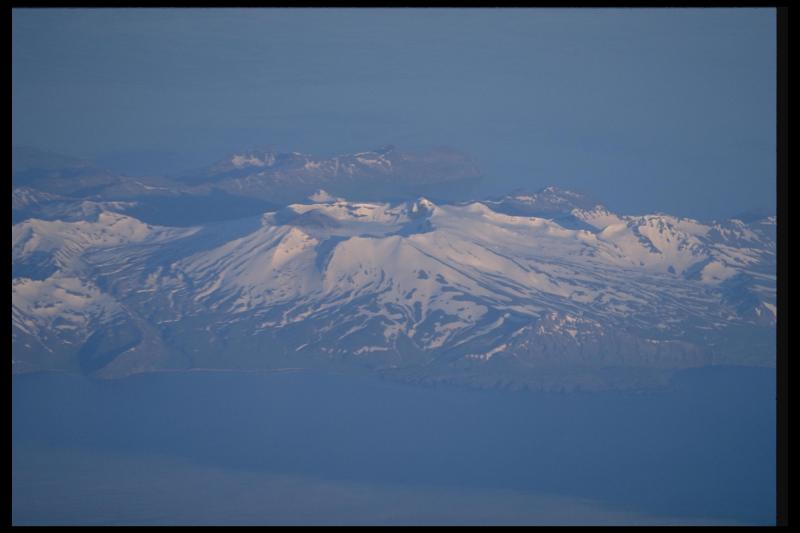 Akutan Volcano on Akutan Island.  View is from the northwest looking through the north-rim breach in the caldera with the active cinder cone visible inside the crater.  The distant promontory is Battery Point, overlooking Broad Bight.