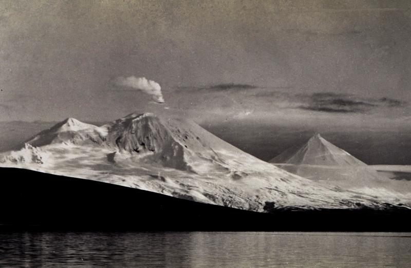View of Mt. Pavlof steaming.  Peak behind and to the left of Pavlof is Little Pavlof; peak to the right (east) is Pavlof Sister. Photograph taken by Captain Hubert A Paton, Coast and Geodetic Survey. Photograph from National Oceanic and Atmospheric Administration/Department of Commerce Photo Library, America's Coastlines Collection.