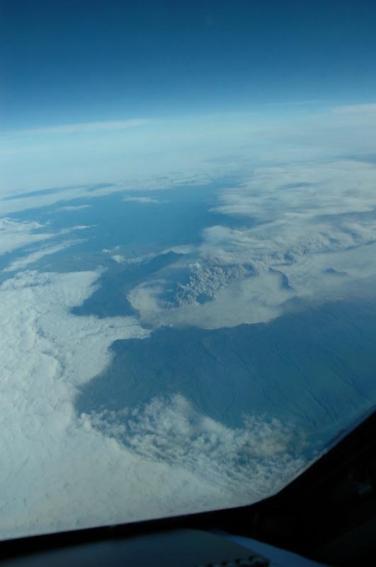 View of Okmok eruption, taken from NE bound Alaska Airlines flight at 35,000 ft above sea level on August 3, 2008 between 20:00 and 20:08. Plume tops estimated to ~ 7,000 ft above sea level using nearby Mount Vsevidof (elev. 7,051 ft / 2,149 m) for reference.