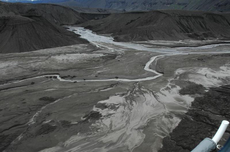 View looking downstream of Crater Creek inside the caldera.  The weakly flowing channel in the middle ground is draining from the approximate position of the old lake while the wider braided channel in the distance emerges from beneath a thick pile of mostly pre-2008 tephra.  Flow is much reduced from normal September conditions as water has been dammed by new ash deposits. Higher flows must have occurred to carry the larger (several m across) blocks of semi-consolidated tephra adjacent to the main channel.  The Gates are out of this view to the upper right.  