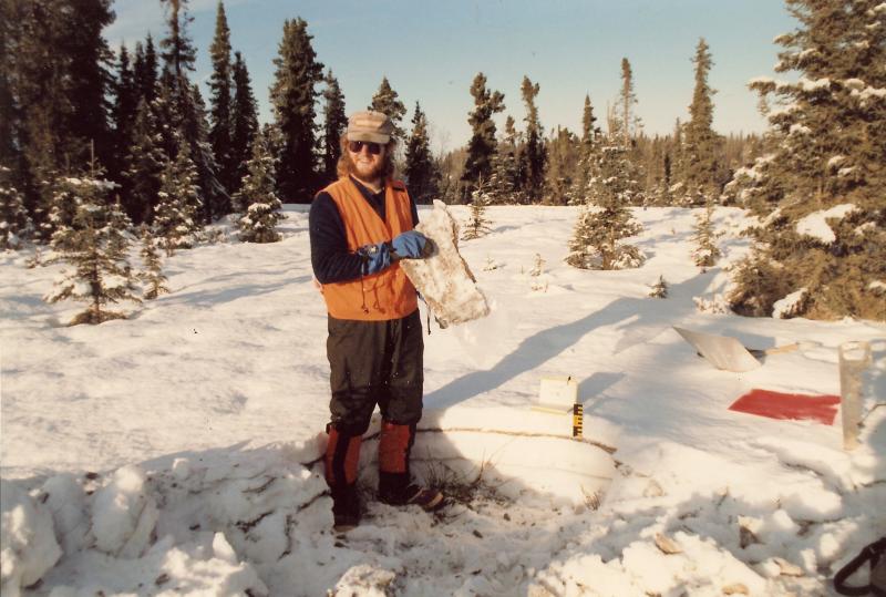 Dave Schneider holding up a frozen ash layer from the January 8, 1990 eruption of Redoubt Volcano. Site location is near the city of Kenai.		