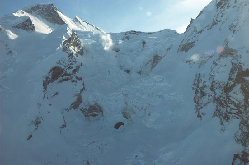 												Upper north flank of Redoubt Volcano showing main fumarolic areas.  Note the ice hole in center-bottom of image; this hole doubled in size during our flight.  See later image 16669 for comparison.  This ice hole reformed since 2/17/09; see image 16673.