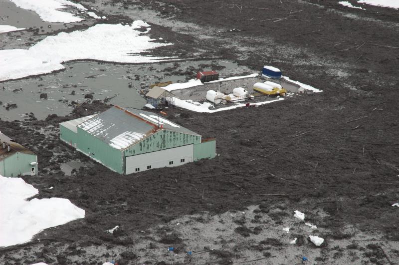 Close up view of the inundated helipad and adjacent service buildings.  Runway is covered by lahar deposit to a depth of at least half a meter.				