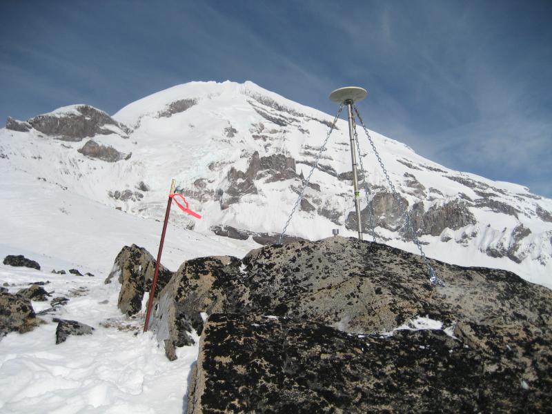 GPS antenna mast deployed at site RBED on large granitic outcrop.  The steep south face of Redoubt Volcano is in the background. Pre-eruption images from GPS fieldwork day, March 18th 2009.