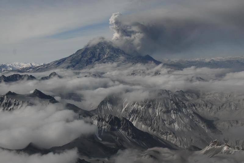 Redoubt volcano and eruption plume on March 31, 2009. View is to the west. Note ash covered slopes in foreground.