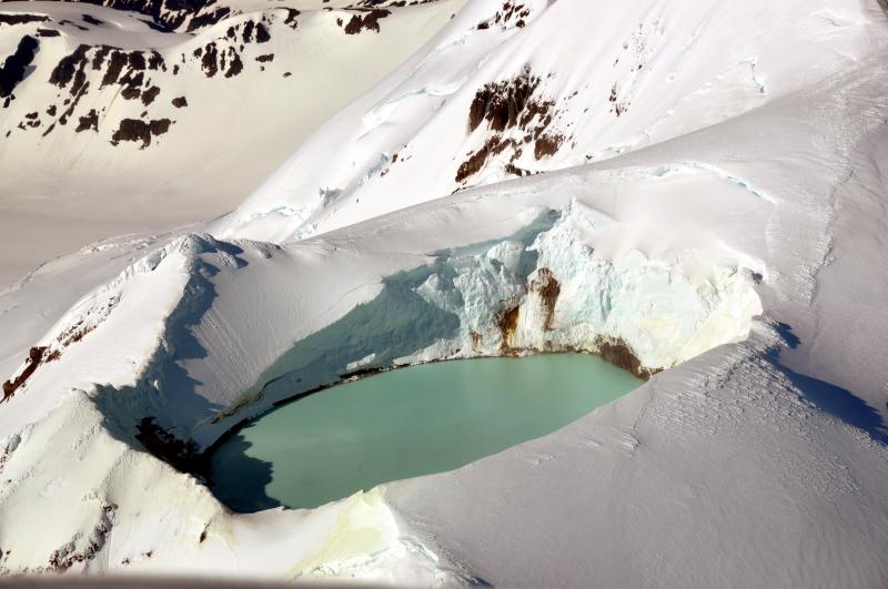 Aerial view of the summits ice-free crater lake at Douglas volcano.  		